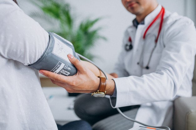 young-male-psysician-with-patient-measuring-blood-pressure_1303-17877-1